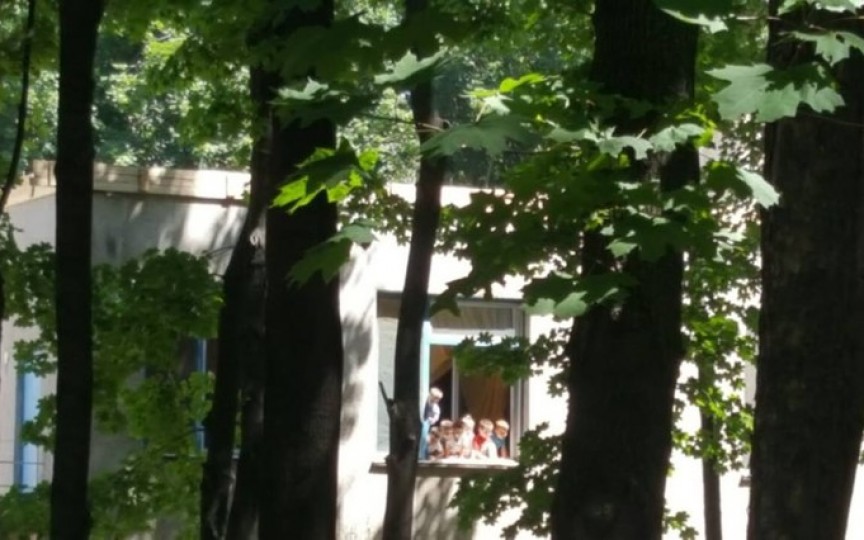 Copiii unei grădiniţe din Chișinău, surprinși pe pervazul unui geam deschis după ce au rămas singuri în grupă